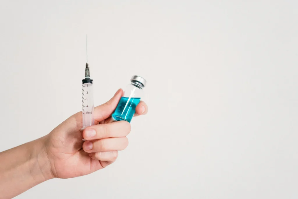 Woman holding syringe and vial for weekly testosterone injection
